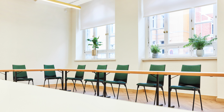 Blick von Tisch auf den gegenüberliegenden Tisch mit grünen Stühlen in dem hellen Anna Auerbach Raum im Volkshaus Jena.  ©JenaKultur, Karoline Krampitz
